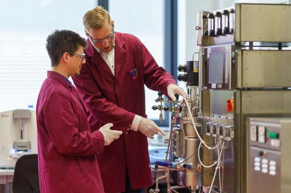 Alberto Alcalá Orozco und Sebastian Bruno Kleeberg arbeiten am Bioreaktor in einem eversyn-Labor.